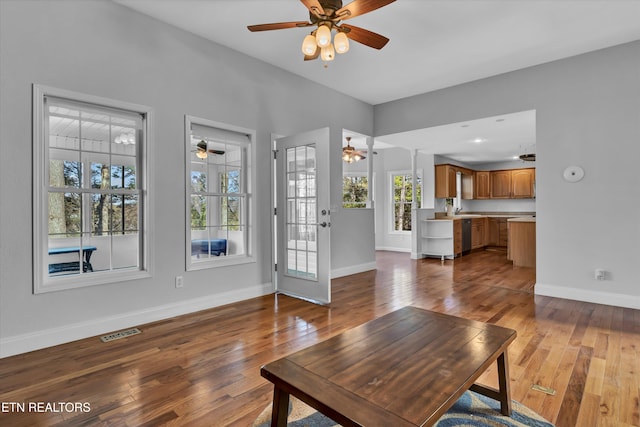 living room with hardwood / wood-style floors, ceiling fan, and sink