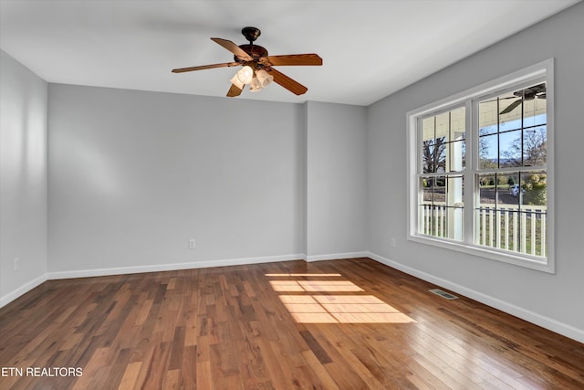 empty room with ceiling fan and dark hardwood / wood-style floors