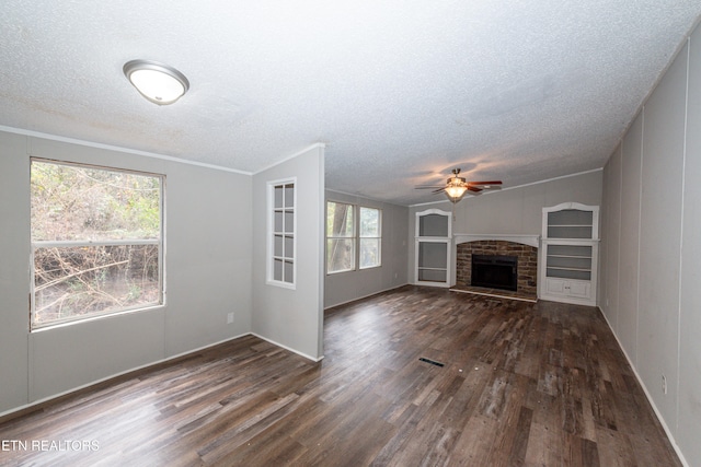 unfurnished living room featuring dark hardwood / wood-style floors, ceiling fan, a textured ceiling, and a fireplace