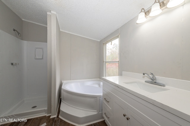 bathroom featuring vanity, a textured ceiling, crown molding, wood-type flooring, and shower with separate bathtub