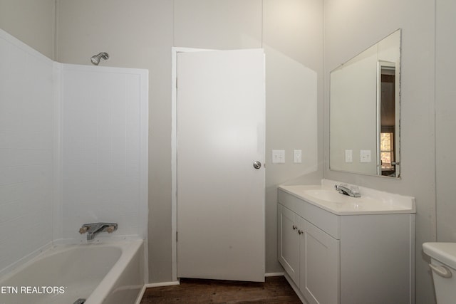 full bathroom featuring washtub / shower combination, vanity, hardwood / wood-style flooring, and toilet