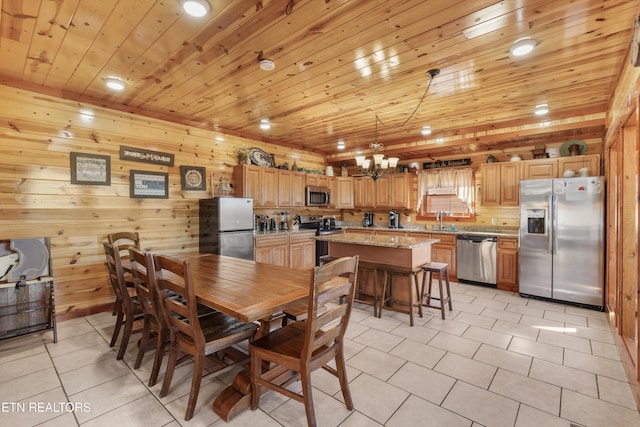 dining room featuring light tile patterned flooring, wood walls, wood ceiling, an inviting chandelier, and sink