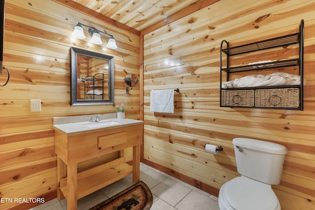 bathroom with tile patterned flooring, vanity, wood ceiling, wooden walls, and toilet