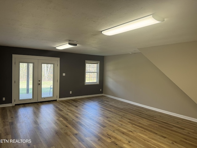 unfurnished room featuring french doors, a textured ceiling, and hardwood / wood-style flooring