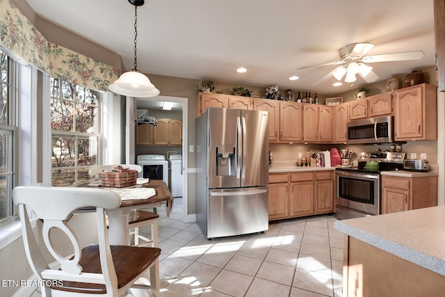 kitchen with stainless steel appliances, ceiling fan, light tile patterned floors, separate washer and dryer, and decorative light fixtures