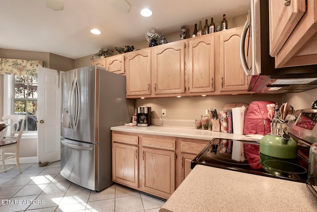 kitchen featuring light brown cabinets, stainless steel appliances, and light tile patterned flooring