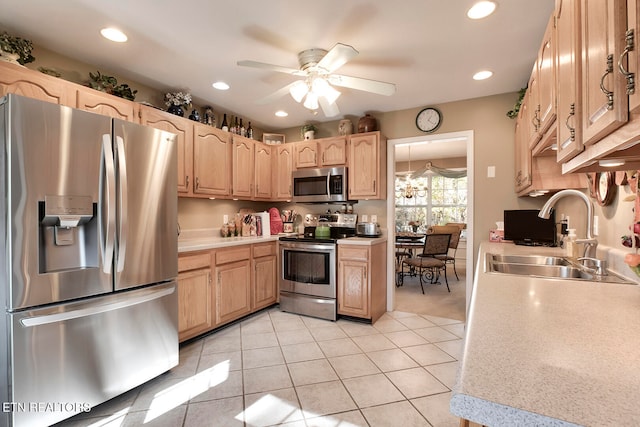 kitchen featuring ceiling fan, sink, light brown cabinets, light tile patterned floors, and appliances with stainless steel finishes