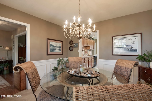 dining area featuring wine cooler, light hardwood / wood-style flooring, a chandelier, and sink