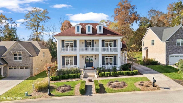 view of front of home with a balcony, a front yard, a porch, and a garage