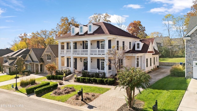 view of front of property with a front yard and a balcony