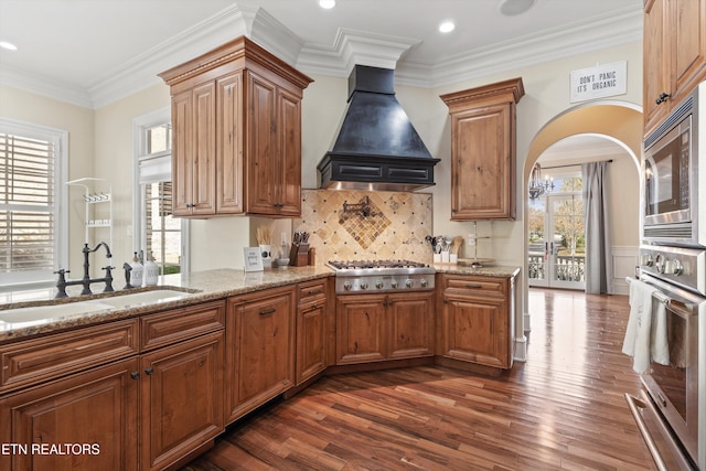 kitchen with dark hardwood / wood-style floors, a wealth of natural light, and custom exhaust hood