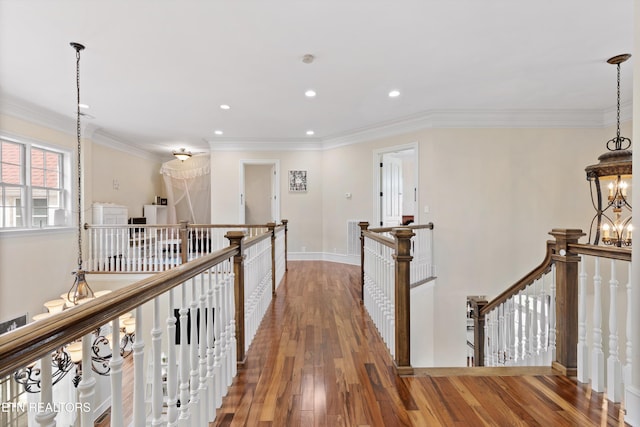 hall with ornamental molding, a notable chandelier, and wood-type flooring