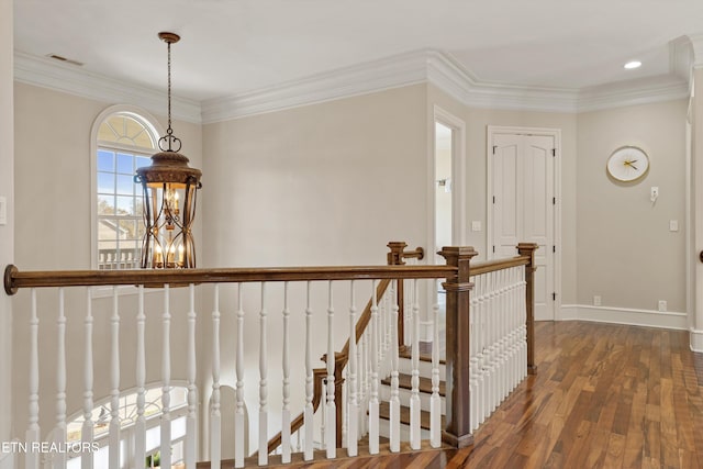 corridor featuring crown molding, dark hardwood / wood-style floors, and a notable chandelier