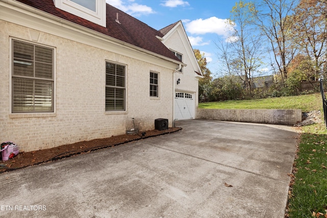 view of side of home featuring a garage and central air condition unit