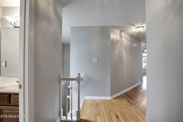 105 Poteau Trce, Loudon, TN 37774 - hallway featuring an upstairs landing, wood-type flooring, a sink, a textured ceiling, and baseboards