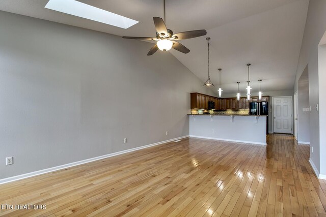 105 Poteau Trce, Loudon, TN 37774 - unfurnished living room with a skylight, ceiling fan, high vaulted ceiling, baseboards, and light wood-style flooring