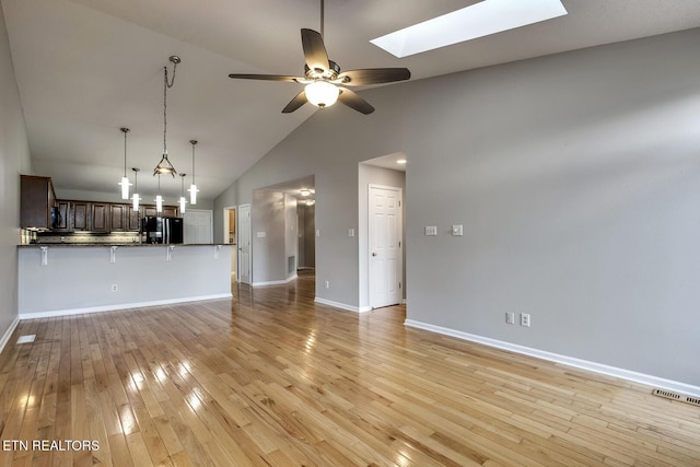 105 Poteau Trce, Loudon, TN 37774 - unfurnished living room featuring a skylight, a ceiling fan, light wood-style floors, baseboards, and high vaulted ceiling