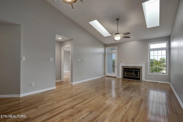 105 Poteau Trce, Loudon, TN 37774 - unfurnished living room with a skylight, ceiling fan, light wood-type flooring, a fireplace, and high vaulted ceiling