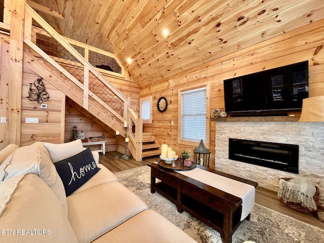 living room featuring wood walls, high vaulted ceiling, a fireplace, wood-type flooring, and wood ceiling