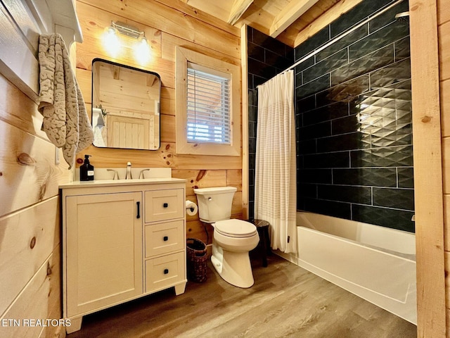 full bathroom with wood walls, wood-type flooring, vanity, and shower / bathtub combination with curtain