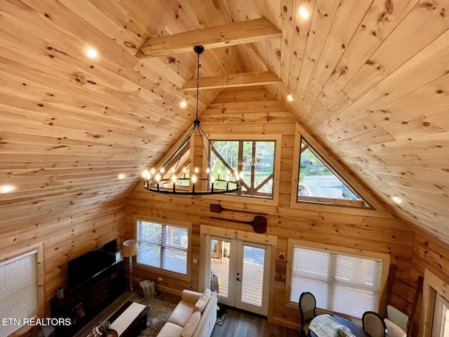 living room featuring an inviting chandelier, wood-type flooring, wood ceiling, wooden walls, and lofted ceiling with beams