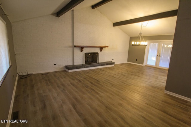 unfurnished living room with vaulted ceiling with beams, a fireplace, brick wall, and dark hardwood / wood-style floors