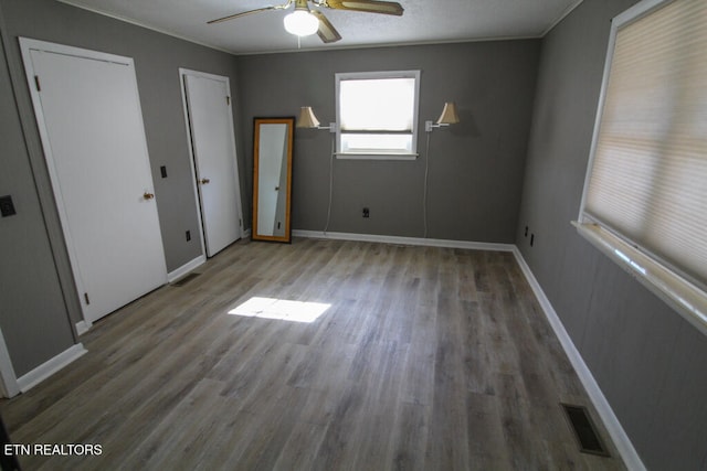 unfurnished bedroom featuring hardwood / wood-style floors, ceiling fan, and crown molding