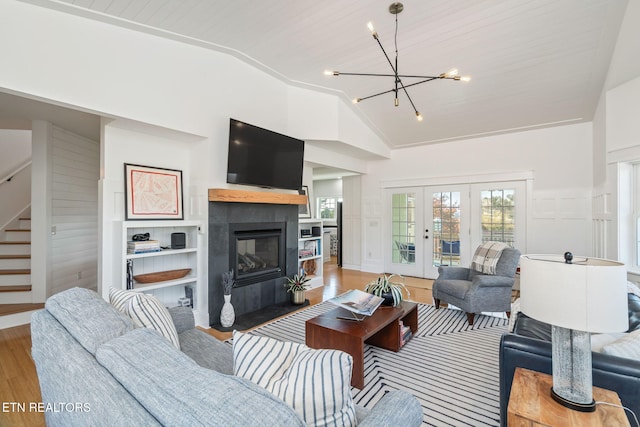 living room featuring wood ceiling, a fireplace, hardwood / wood-style floors, a chandelier, and lofted ceiling