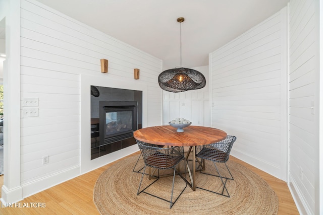 dining space featuring light hardwood / wood-style flooring and a tiled fireplace