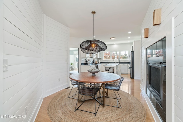 dining space with sink and light hardwood / wood-style floors