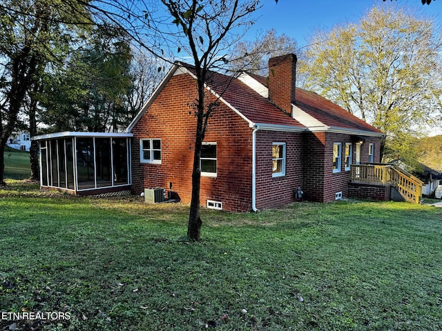 view of home's exterior featuring central AC unit, a lawn, and a sunroom