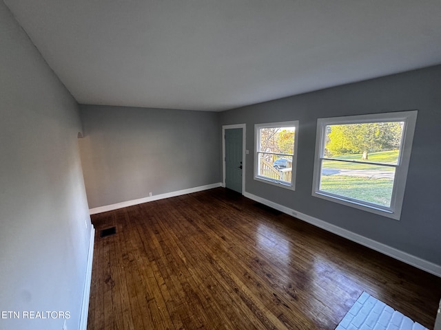 empty room featuring lofted ceiling and hardwood / wood-style flooring