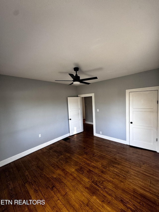 unfurnished bedroom featuring ceiling fan and dark hardwood / wood-style flooring