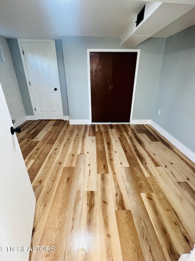 unfurnished bedroom featuring wood-type flooring and a closet