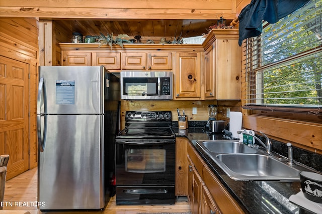 kitchen featuring stainless steel appliances, dark stone counters, sink, wooden ceiling, and light hardwood / wood-style flooring