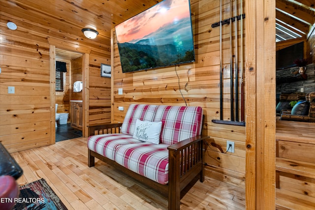 sitting room with wood walls, hardwood / wood-style flooring, and wood ceiling