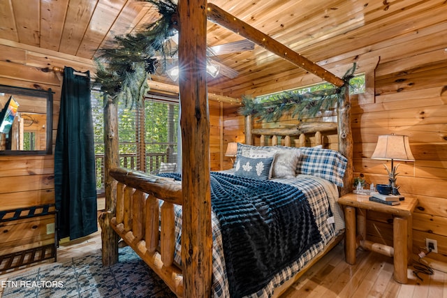 bedroom featuring wooden walls, hardwood / wood-style flooring, and wooden ceiling