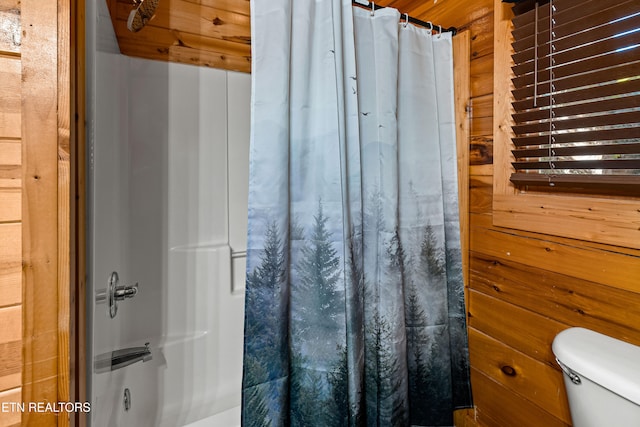 bathroom with wood walls and toilet