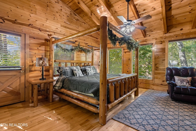 bedroom featuring light hardwood / wood-style flooring, wooden walls, multiple windows, and wood ceiling