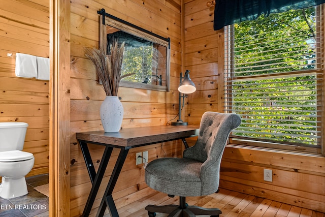 office area featuring wood-type flooring and wooden walls