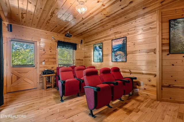 home theater room with wooden walls, wood ceiling, and light hardwood / wood-style floors