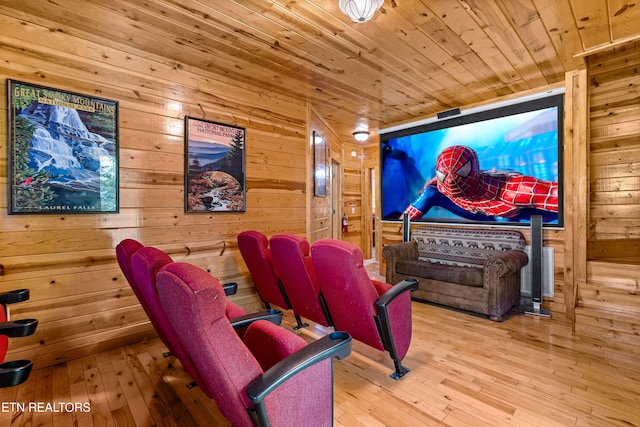 home theater room with wood walls and light wood-type flooring