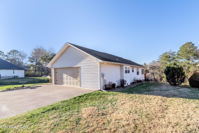 view of side of property with a garage and a lawn