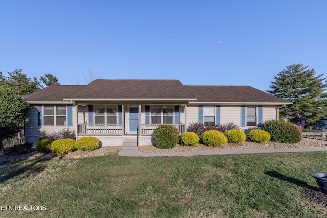 ranch-style house featuring covered porch and a front lawn