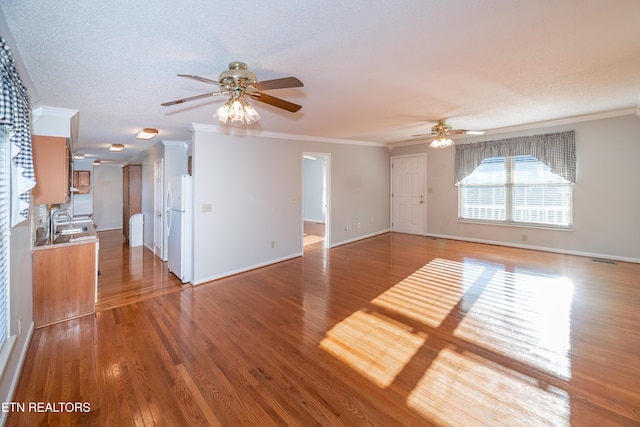 unfurnished living room featuring hardwood / wood-style floors, ceiling fan, and ornamental molding