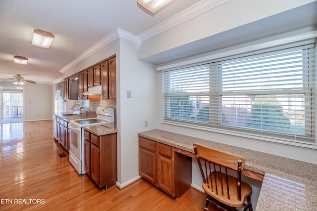 kitchen with ceiling fan, crown molding, sink, electric range, and built in desk