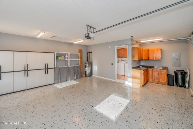 garage featuring washing machine and dryer, electric water heater, electric panel, and a garage door opener