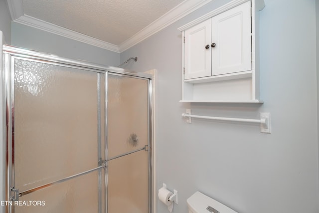 bathroom with crown molding, toilet, a shower with door, and a textured ceiling