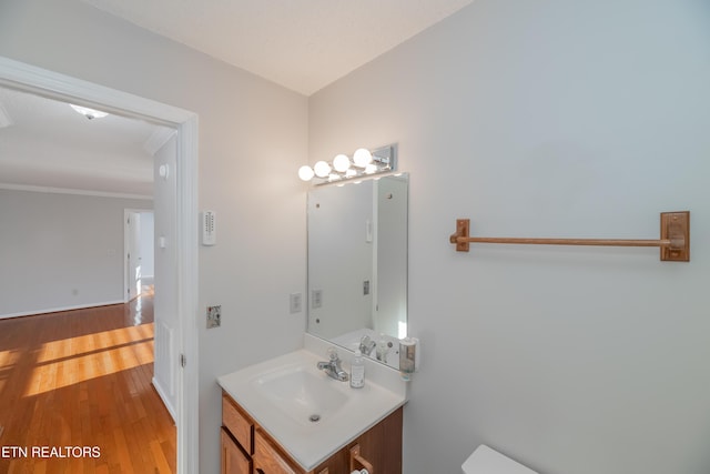 bathroom featuring toilet, vanity, and hardwood / wood-style flooring