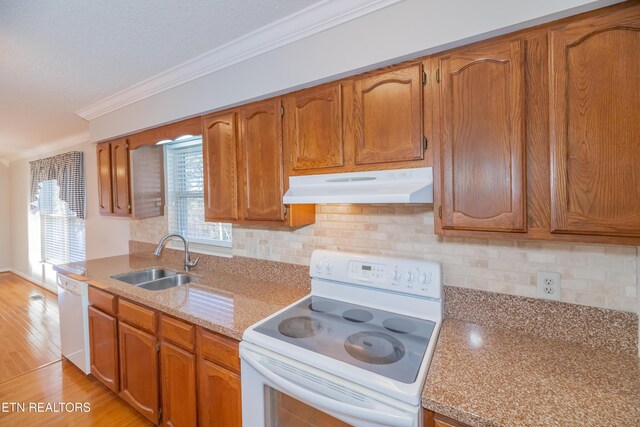 kitchen with backsplash, crown molding, sink, and white appliances